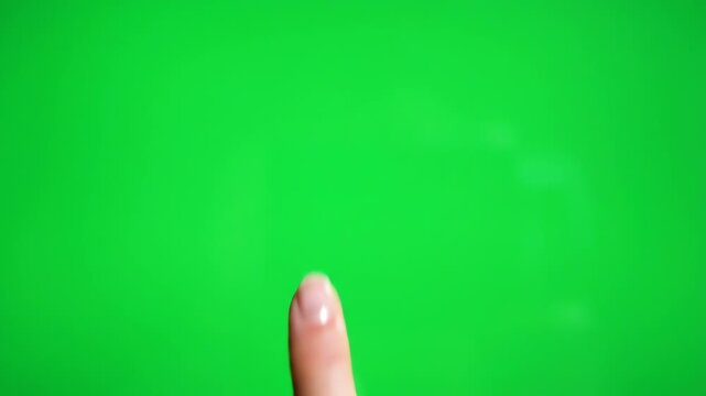 Close-up of a woman's finger pointing on a green screen background