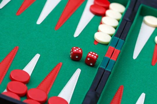 Backgammon Board Game in Progress with Dice and Checkers on a green felt surface