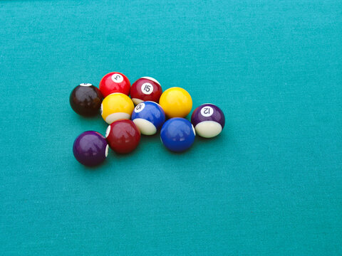 Billiard Balls Grouped on Green Felt Pool Table Surface game of pool or snooker