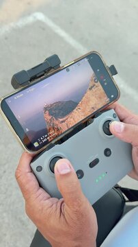 Man Flying Drone Controller with Mallorca Coast View