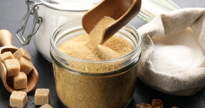 Woman with different types of sugar at black table, closeup