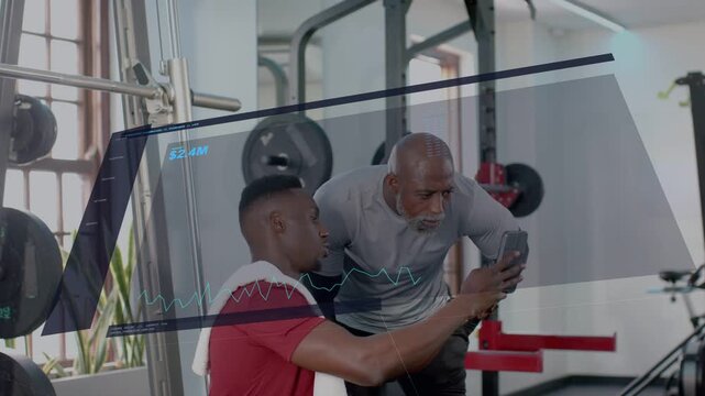 Trainee adjusting smartphone, trainer leaning reviewing metrics with waveform $2