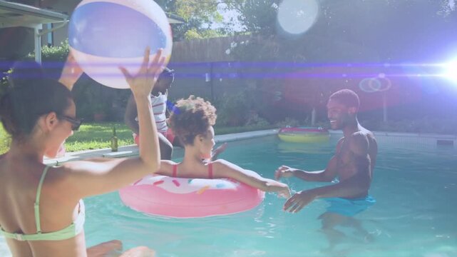 Seated man tossing beach ball, woman in pink pool float reaching, friends passing ball, for leisure