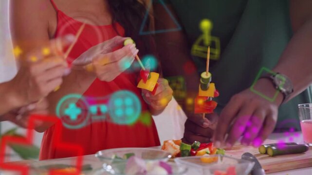 Two friends threading food skewers on kitchen counter, others joining as AR HUD guiding tasting