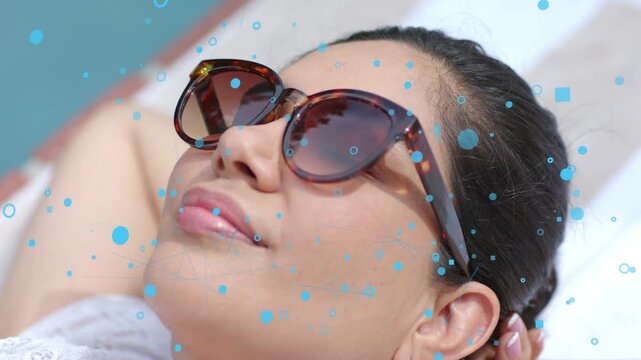 Woman reclining, hand adjusting, camera zooming, blue bubbles drifting over sunglasses for fashion