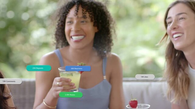 Three women posting on social media while middle raising cocktail, bubbles rising, panning right