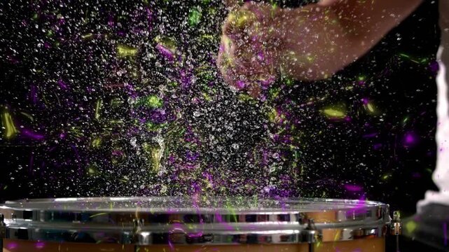 Male drummer striking snare on black, sparking purple or gold chalk swirls then settling for music