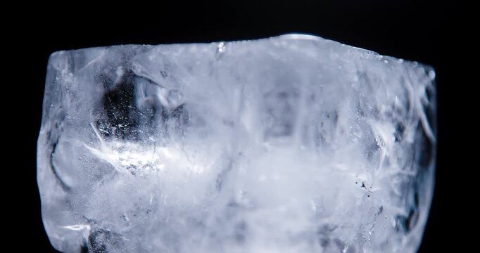 Ice cube closeup over black background. Real ice structure.