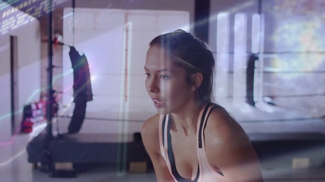 Female athlete bending forward catching breath after fitness set while light streaks sweeping body