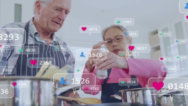 Senior couple cooking, lifting pasta and grinding spice, causing social media icons rising over pot