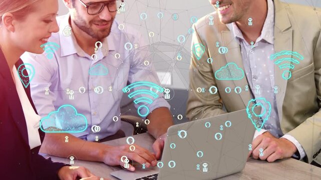 Coworkers leaning over laptop, typing and activating floating tech icons for cloud demo, smiling