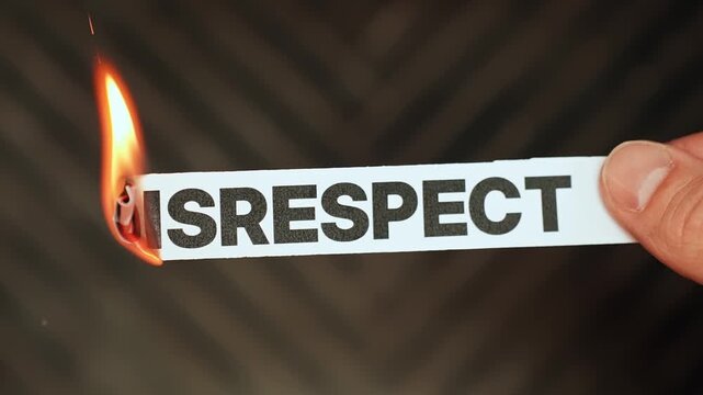Burning &ldquo;disrespect&rdquo; label held by hand, symbolizing dignity, mutual respect, healthy boundaries, and leaving rude behavior and toxic treatment behind.
