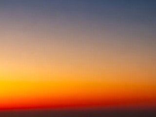 Fototapeta premium Vibrant Sunset Sky Orange, Yellow, and Blue Gradient Background, Peaceful Nature
