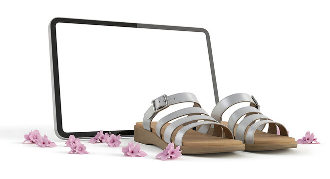 Pair of elegant silver gladiator sandals displayed with pink blossoms in front of a tablet with a blank screen, showcasing online shopping for summer footwear