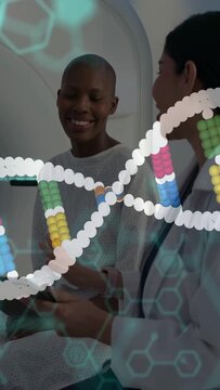 Vertical video: Doctor tapping tablet causing AR DNA helix, patient watching, smiling, sharing data