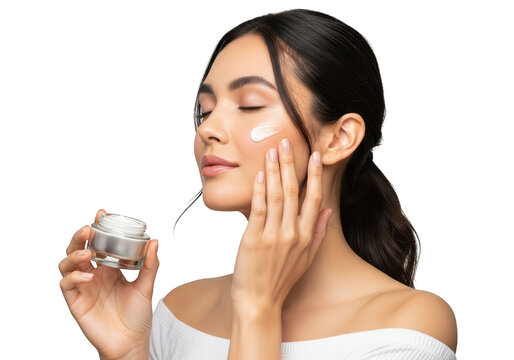 Content young woman applying a moisturizing facial cream to her cheek with a gentle touch, representing a daily self-care beauty ritual for radiant and healthy skin