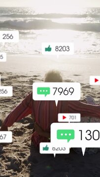 Vertical video: Senior couple holding on shore, incoming social notifs rising, partly hiding them