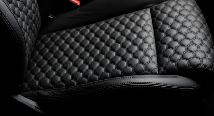 Fototapeta premium Close-up of a luxurious black quilted leather car seat with intricate diamond stitching, emphasizing a high-end interior and sophisticated automotive design
