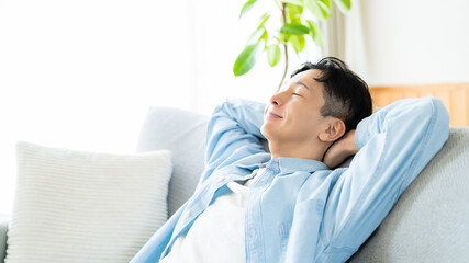 ソファでリラックスする男性のライフスタイルイメージ, Man Relaxing...