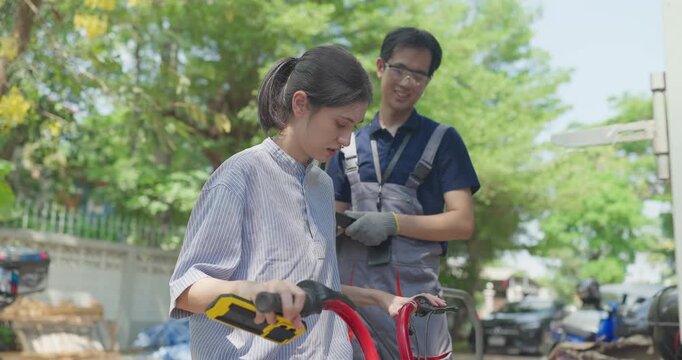 Startup founder and engineer inspect, document and test a minibike prototype outdoors at small business workshop during product development, repair review and SME innovation.
