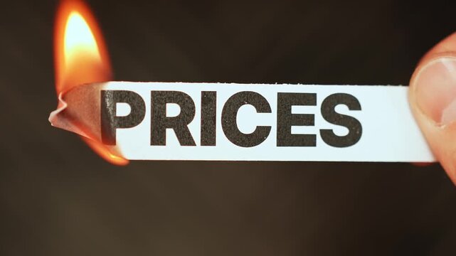 Burning &ldquo;PRICES&rdquo; concept symbolizing falling costs, easing inflation, discounts, affordability, and improved consumer spending power.