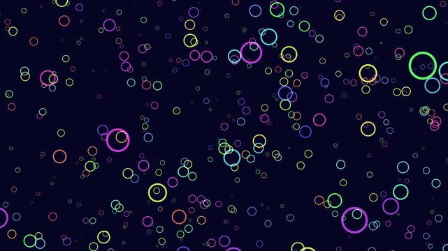 Abstract motion footage of colorful neon bubble rings drifting across a dark blue background, creating a playful bokeh pattern for modern overlays, intros, and backdrops
