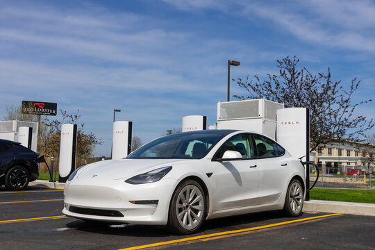 White Tesla Model 3 charging at Supercharger station