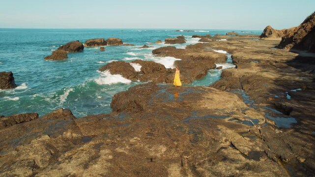 Woman exploring rocky seashore during sunny tropical day in Costa Rica