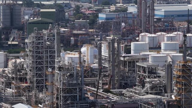 Aerial close up drone video of plastic manufacturing and chemical industry in Mueang Rayong District, Thailand, showing industrial production, petrochemical infrastructure, and factory operations.