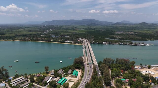 High angle aerial view of sarasin bridge linking phuket island to the mainland, with steady traffic crossing over turquoise andaman sea waters and coastal landscape below