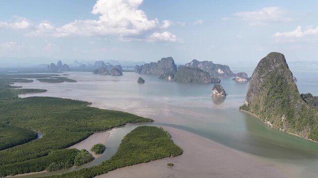 Expansive aerial panorama over phang nga bay in thailand, revealing dramatic limestone karsts, lush green mangrove forests, and the calm waters of the andaman sea under a partly cloudy sky