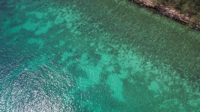 Rocky Shoreline With Turquoise Crystalline Ocean Waters And Coastal Trees. Khlong Hin Beach In Trat, Thailand. aerial topdown shot