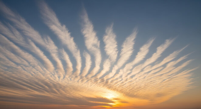 Dramatic cloud formation with parallel lines against a gradient blue and orange sky