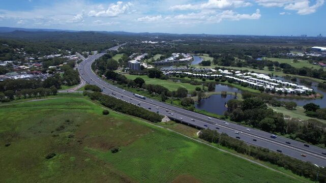 Road Traffic Over Pacific Motorway Near Firth Park In Mudgeeraba, Queensland, Australia. Aerial Drone Shot