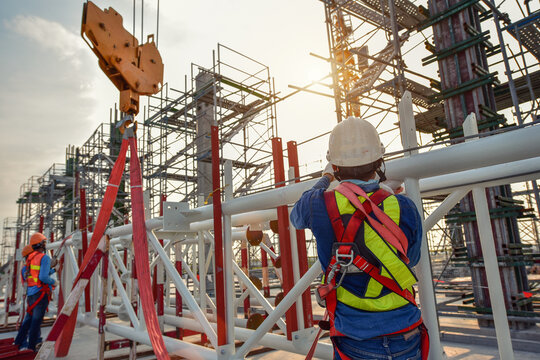 Working at height equipment. Fall arrestor device for worker with hooks for safety body harness on selective focus. Worker as a background.