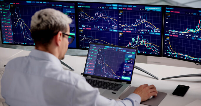 Latino Stock Trader Monitors Several Market Screens During Workday