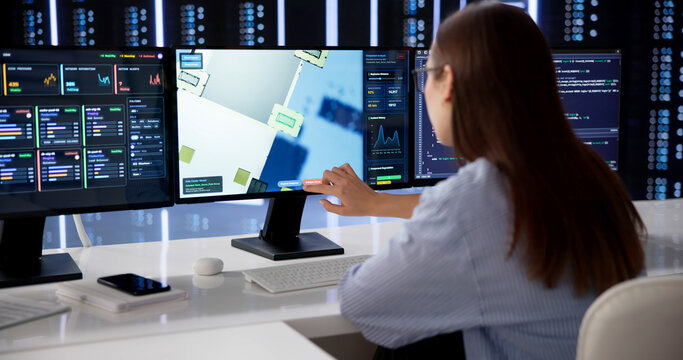 Woman Systems Engineer Monitors Multiple Server Data Screens