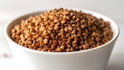 Fototapeta premium A white bowl overflowing with brown buckwheat grains