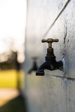 taps on the side of a brick wall at a sports club