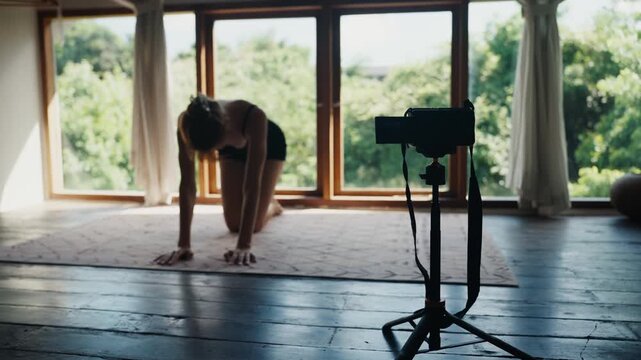 Woman vlogging yoga practice at home