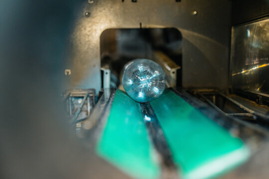 blur of plastic bottle moving on a green conveyor belt inside industrial recycling machinery