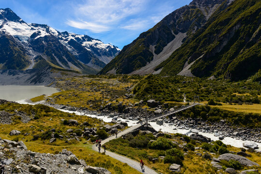 Hikers crossing a swing bridge in an alpine region