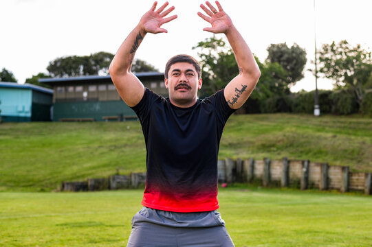 A male athlete trains on a green field, focusing on improving his football techniques.