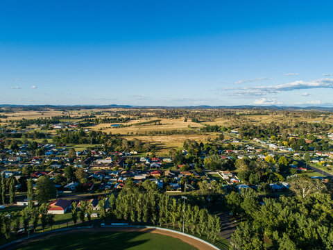 Green trees around Glen Innes Showground ring in bright sunlight from aerial view in summer 