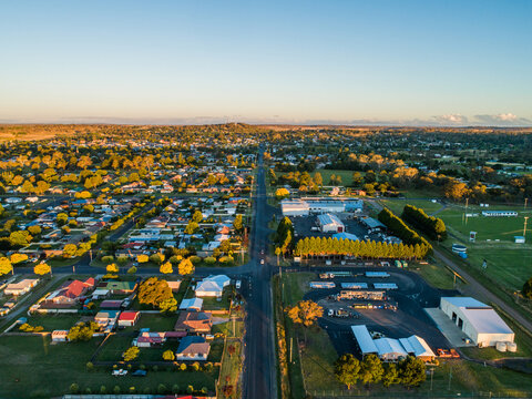 green trees and rooftops of rural town touched by last light of summer day in NSW Australia