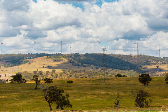Windfarm wind turbines on hillside with clouds overhead