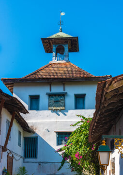 This image shows the historic clock tower located next to the Paradesi Synagogue in the Mattancherry neighborhood of Kochi, India.