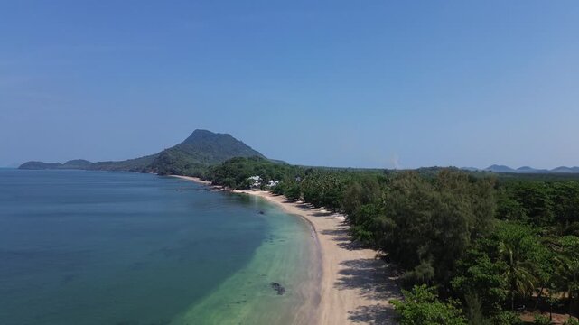 Aerial establishing shot of tropical coastline on Koh Jum Thailand with calm sea sandy beach and green vegetation smooth motion cinematic island landscape for film and travel projects
