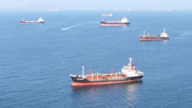 fast patrol boat LPG gas and oil tanker ships anchored in the ocean, with a fast patrol boat in the foreground. Global energy transport, war energy crisis, and Strait of Hormuz blockade