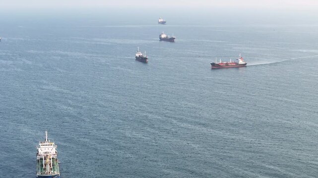 fast patrol boat LPG gas and oil tanker ships anchored in the ocean, with a fast patrol boat in the foreground. Global energy transport, war energy crisis, and Strait of Hormuz blockade
